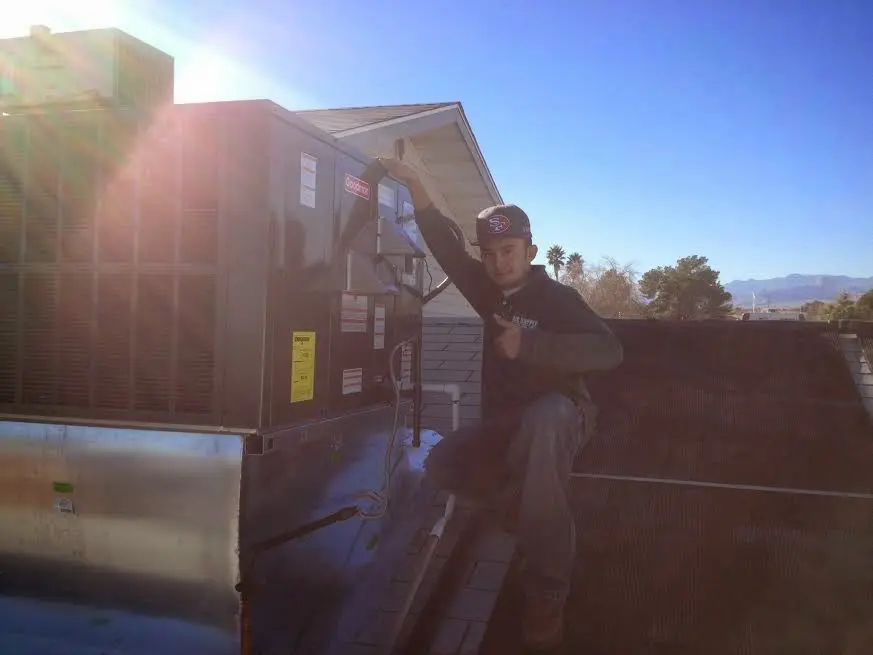 HVAC technician performing Heat Pump Repair on a rooftop unit in Conyers